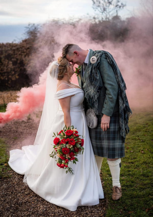Bride and groom with wedding flowers by Thistle Du Florist