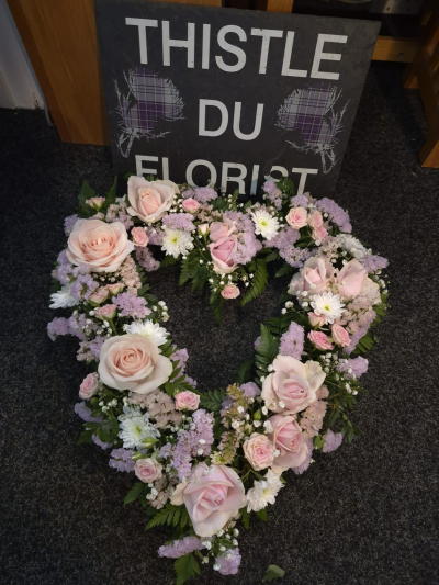 Gentle Love Wreath - A delicate open wreath in soft pink and lilac tones, offering a heartfelt final farewell.